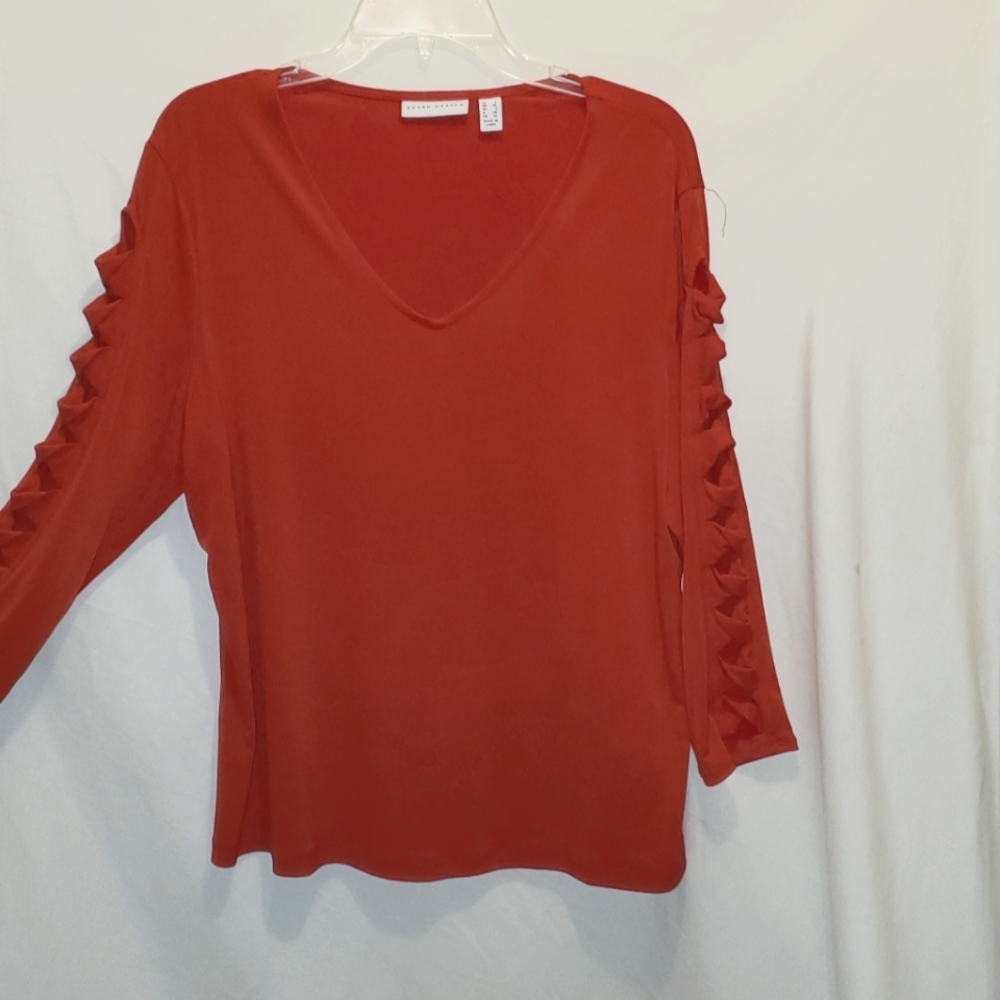 SUSAN GARVER RED TOP WITH SLICED AND TWISTED ON ARM.